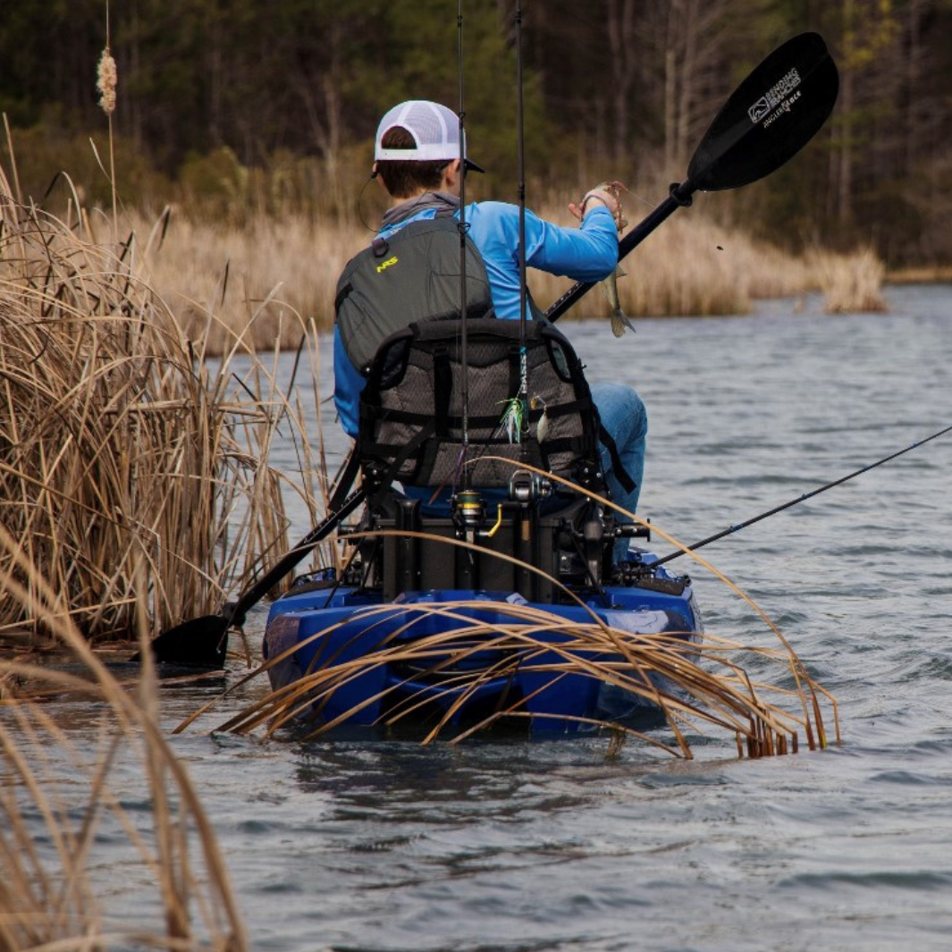 Fisherman in a kayak facing away from camera. Angler Ace used to move through weeds.