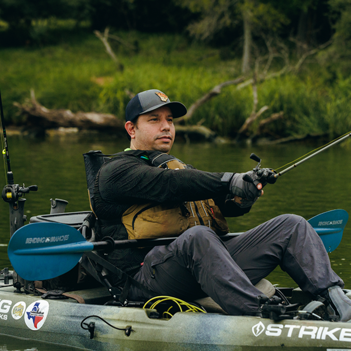 angler classic snap button tidal blue paddle across angler's lap while casting 