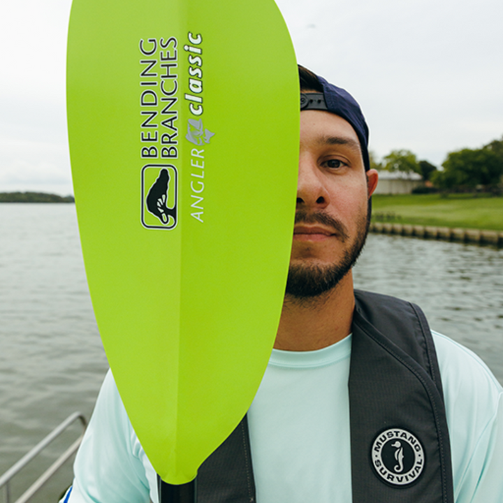 angler classic snap button electric green in front of half of a man's face - lifestyle shot