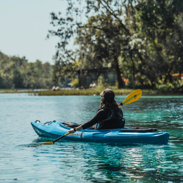 woman kayaker in blue liquid logic boat paddling with the yellow bounce paddle