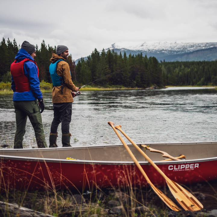Catalyst 11 and Catalyst ST leaning against red canoe with two men fishing in the background