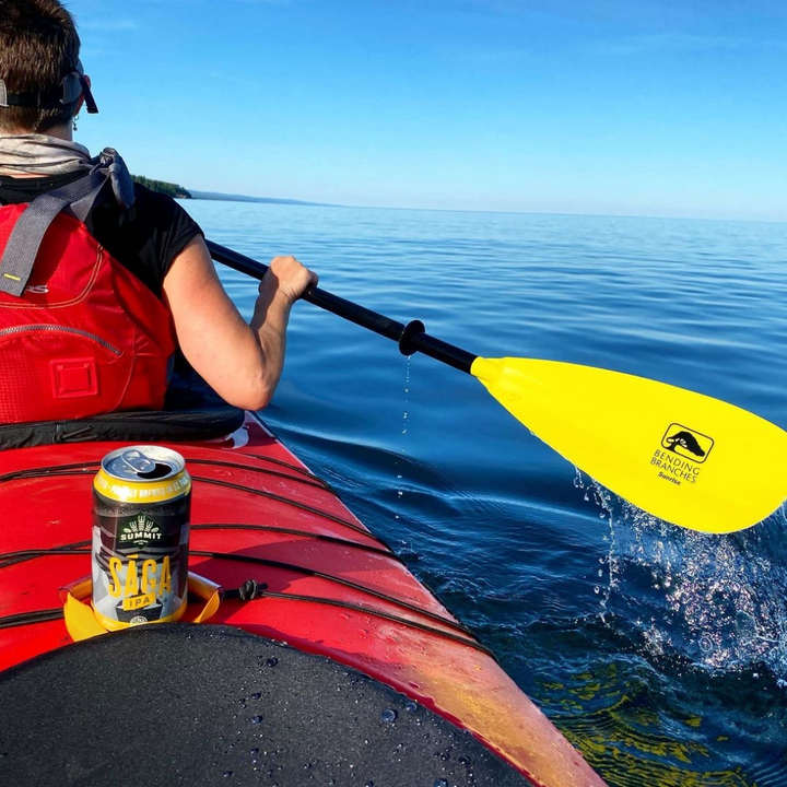 Sunrise Glass Yellow being paddled. Tandem kayak with water dripping off blade.