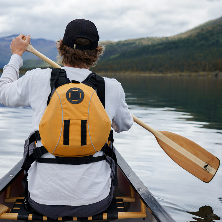 Male bow paddler paddling with the Traveler wooden canoe paddle