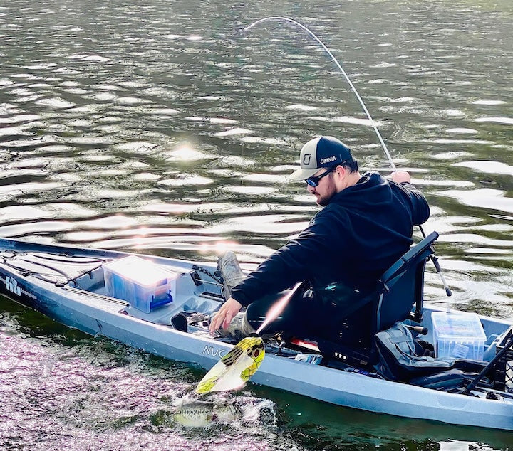 kayak angler pulls in a fish