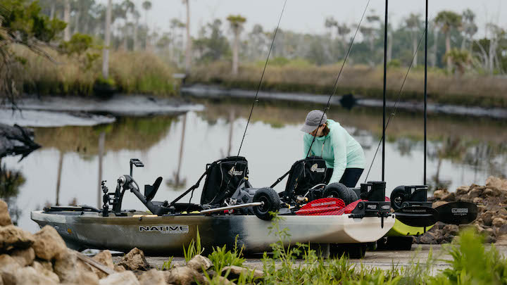 woman with 2 pedal fishing kayaks, getting them ready for the water