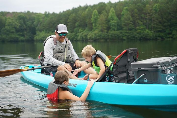 dad and two young boys enjoying a tandem fishing kayak on the water