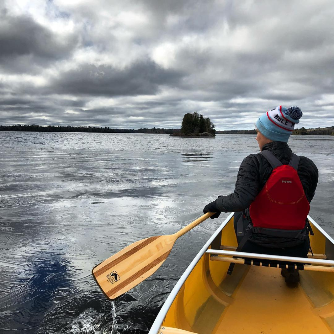 Photo taken from the stern of the Arrow wooden canoe paddle coming out of the water during a recovery stroke