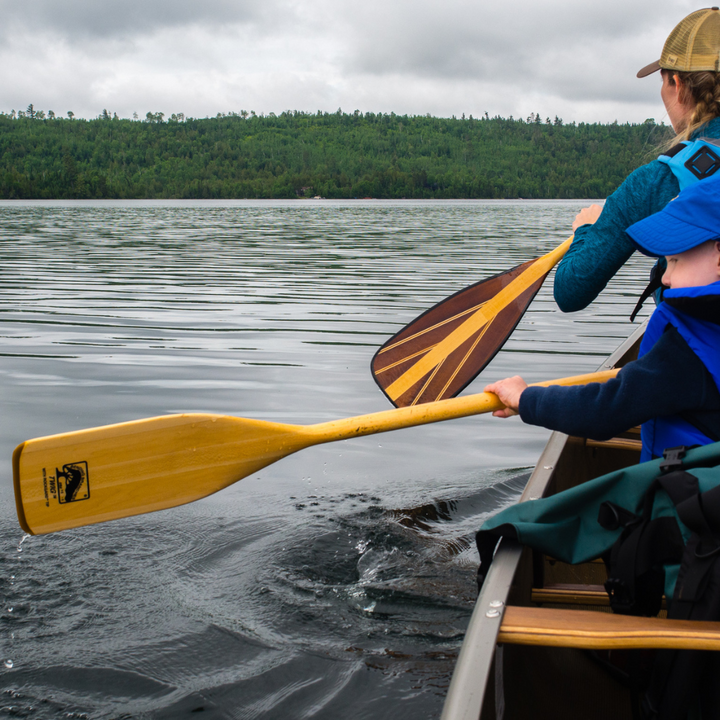 Small boy using his Twig paddle out on the water. Java 11 used by the bow paddler in the background