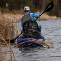 Fisherman in a kayak facing away from camera. Angler Ace used to move through weeds.