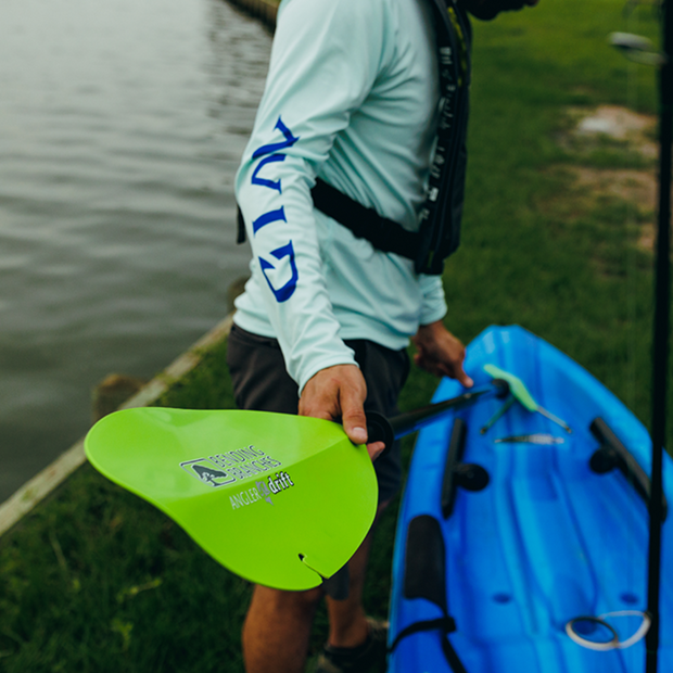 angler drift snap button electric green being attached to kayak on shore