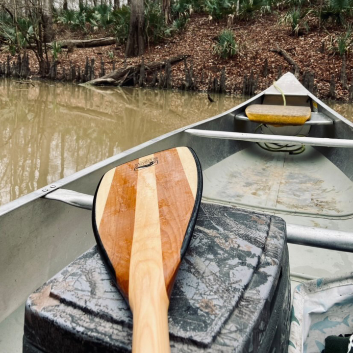 Explorer Plus wooden canoe paddle laying across a canoe