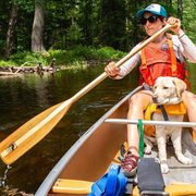 Female stern paddler using the Traveler with a yellow lab puppy sitting between her legs
