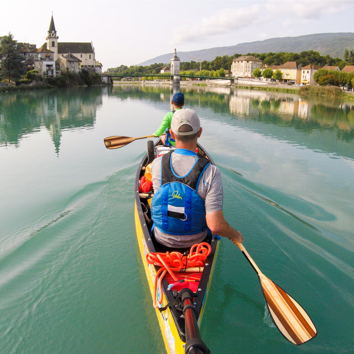 Two people in a canoe paddling a river in Europe